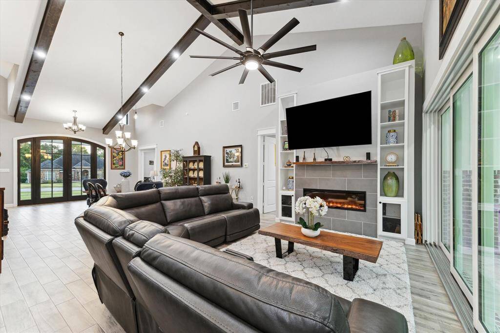 Custom built-ins with electric fireplace create a warm ambiance while overlooking the back yard space through custom sliding glass doors.