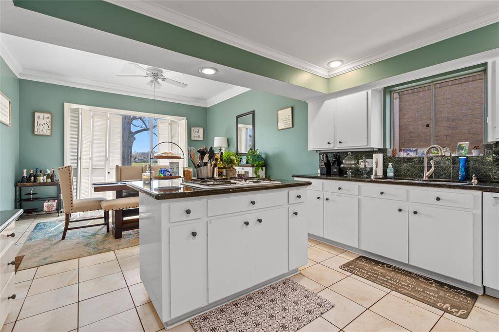 This spacious kitchen offers plenty of storage, counter space, and natural light. The central island provides additional workspace, perfect for meal prep or casual dining. Overlooking the dining area, this kitchen is ideal for cooking and entertaining with ease.