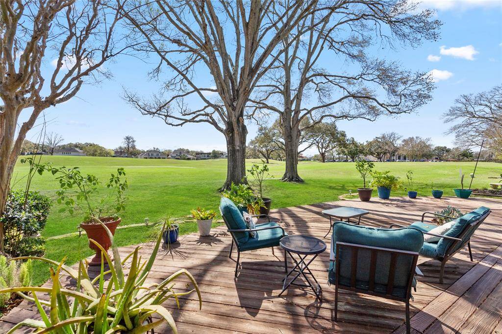 This spacious backyard deck offers stunning golf course views, creating a serene and picturesque setting. Surrounded by mature trees and lush greenery, the outdoor space provides the perfect spot for relaxation or entertaining. The wooden deck seamlessly blends with the natural landscape, while ample space allows for various seating arrangements to enjoy the peaceful surroundings.