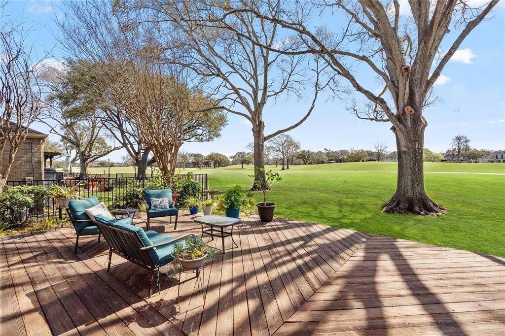 This backyard deck provides a seamless connection to the golf course, offering an expansive and peaceful outdoor retreat. The well-maintained wooden deck is complemented by lush greenery, mature trees, and open views, creating an ideal setting for relaxation or entertaining. The natural surroundings enhance the serene ambiance, making this space a perfect spot to unwind.