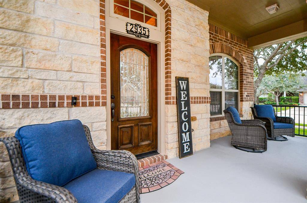 A stunning leaded glass front door, beautifully framed by stone and brick, creates a grand entrance that welcomes you home and is sure to leave a lasting impression on your guests.