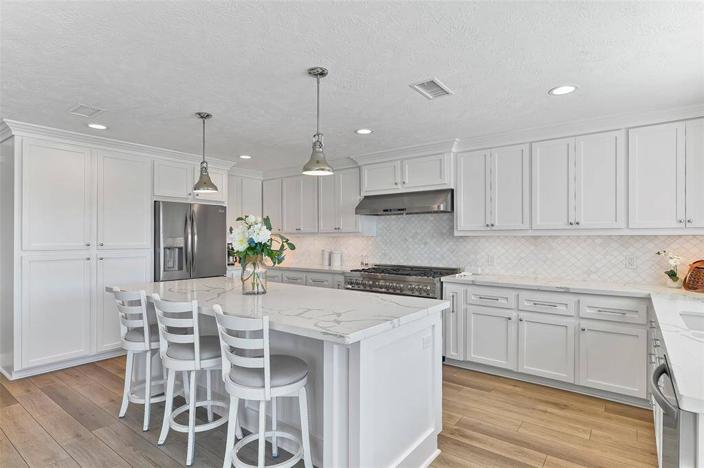 The kitchen also has a french door stainless steel refrigerator & double freezer drawers. To the left of the refrigerator is the pantry which has a coffee bar inside.