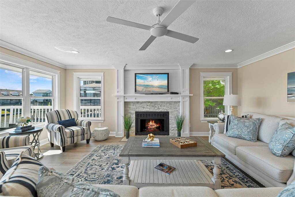 The living room features a stone surround gas log fireplace with accent ship lap wall & beautiful wood work surround.