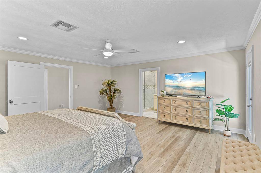 This spacious bedroom features luxury vinyl plank flooring, recessed lighting, crown molding & direct access to the private north facing deck.