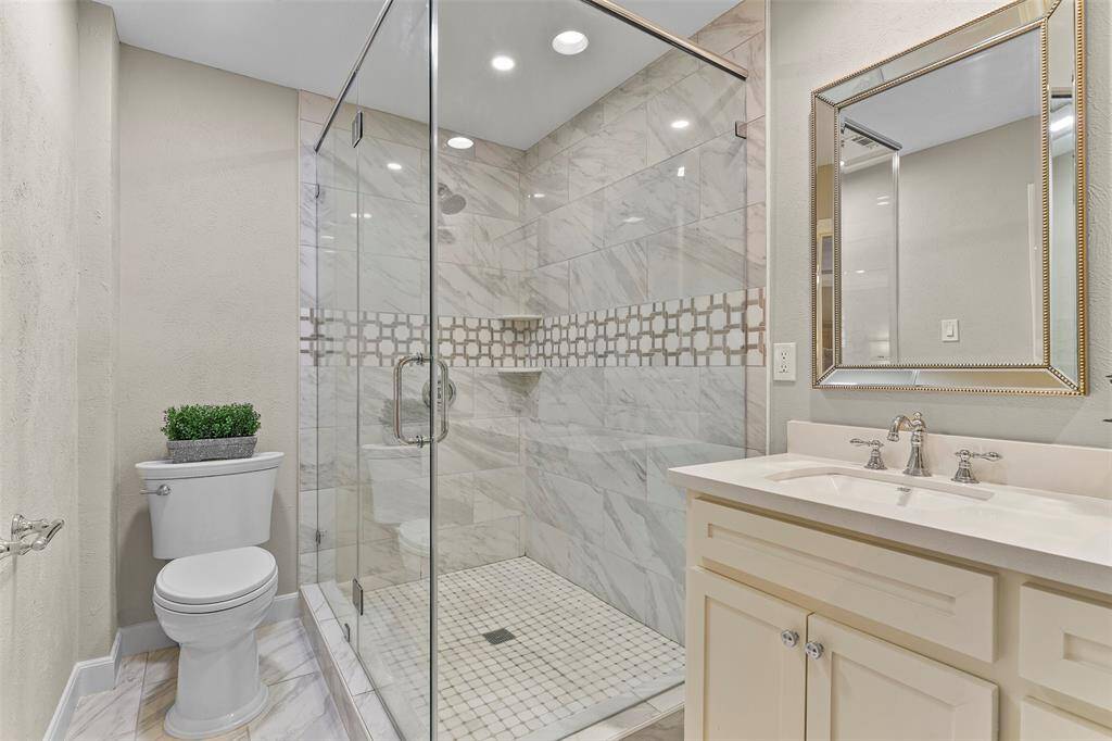 The custom tile surround shower glass enclosure.