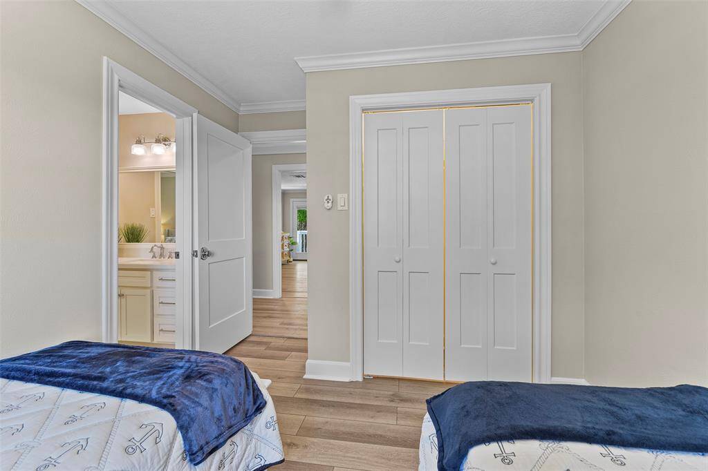 This bedroom features ample closet space, luxury vinyl plank flooring, crown molding & direct access to the Hollywood bathroom.