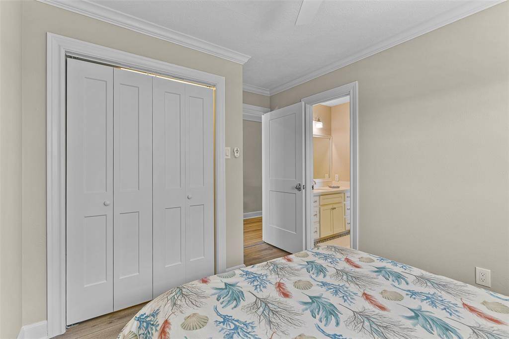 This bedroom features ample closet space, luxury vinyl plank flooring, crown molding & direct access to the Hollywood bathroom.