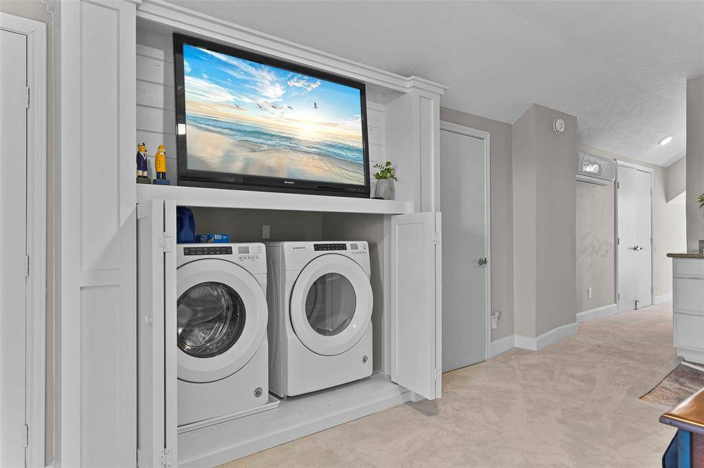 The front loader washer & dryer are cleverly hidden in the built-in cabinet under the TV.