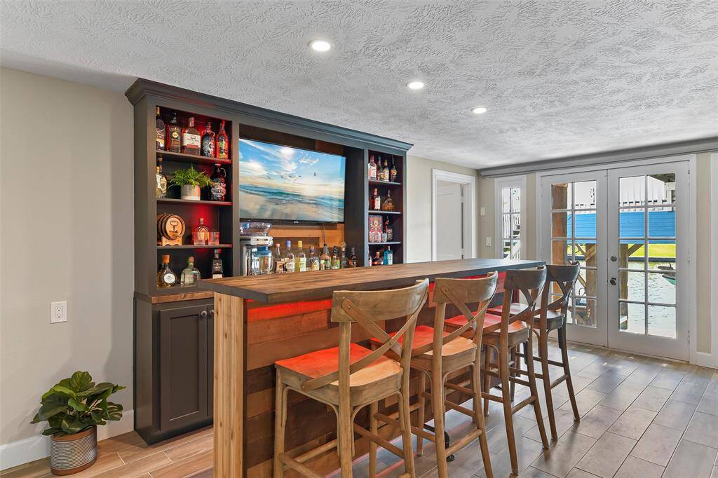 The bottom level of the home features wood look tile flooring & a fantastic bar which you can easily access from the outside.