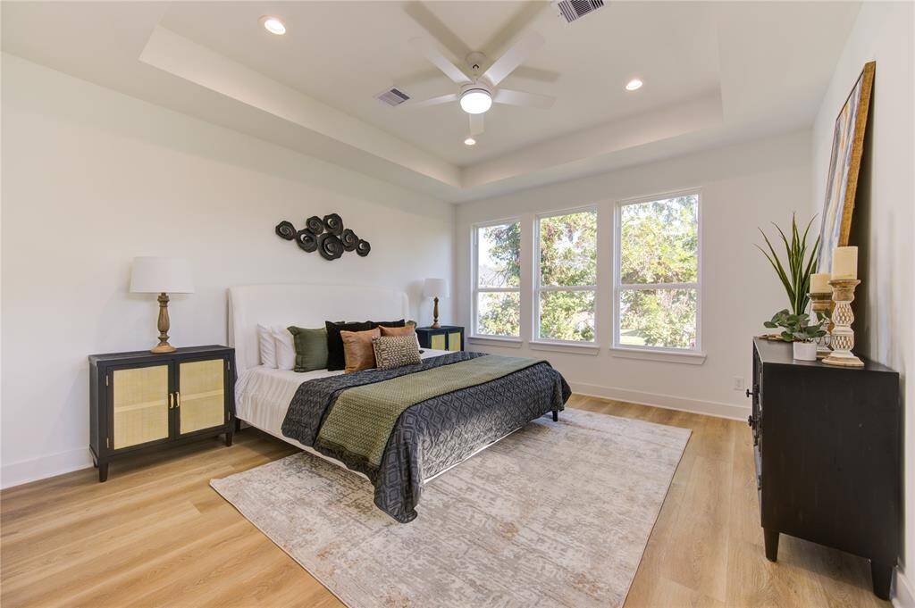 Primary bedroom features tray ceilings and great natural light