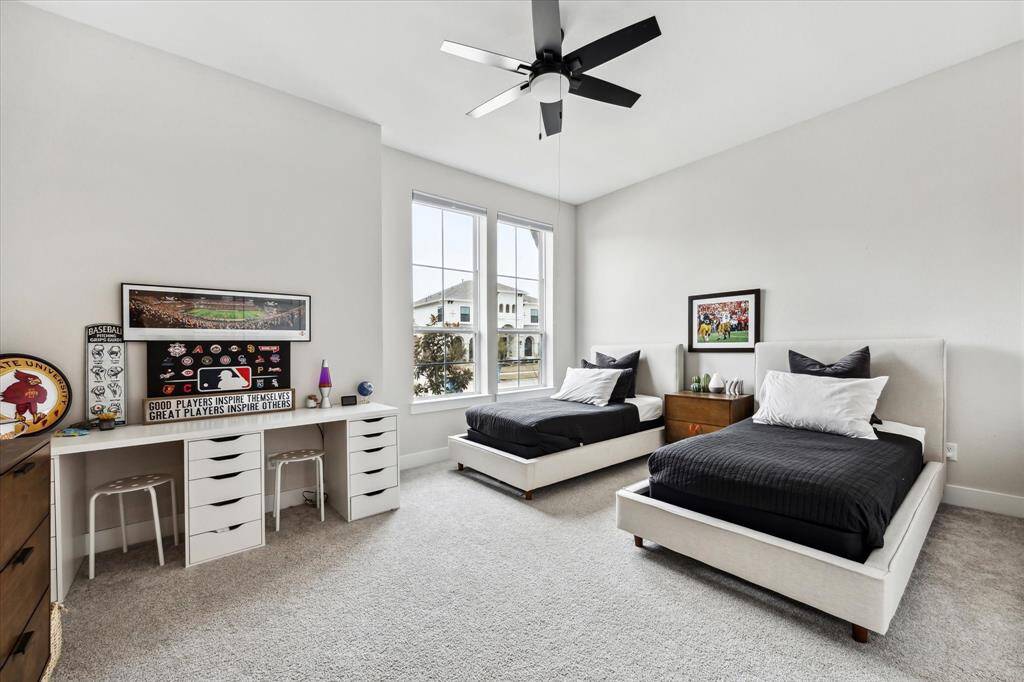 Bright secondary bedroom with neutral tones, ample closet space, and two large windows for abundant natural light.