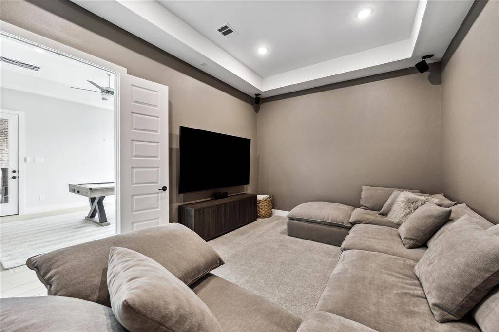 This cozy Media Room features recessed lighting and a coffered ceiling, perfect for movie night!