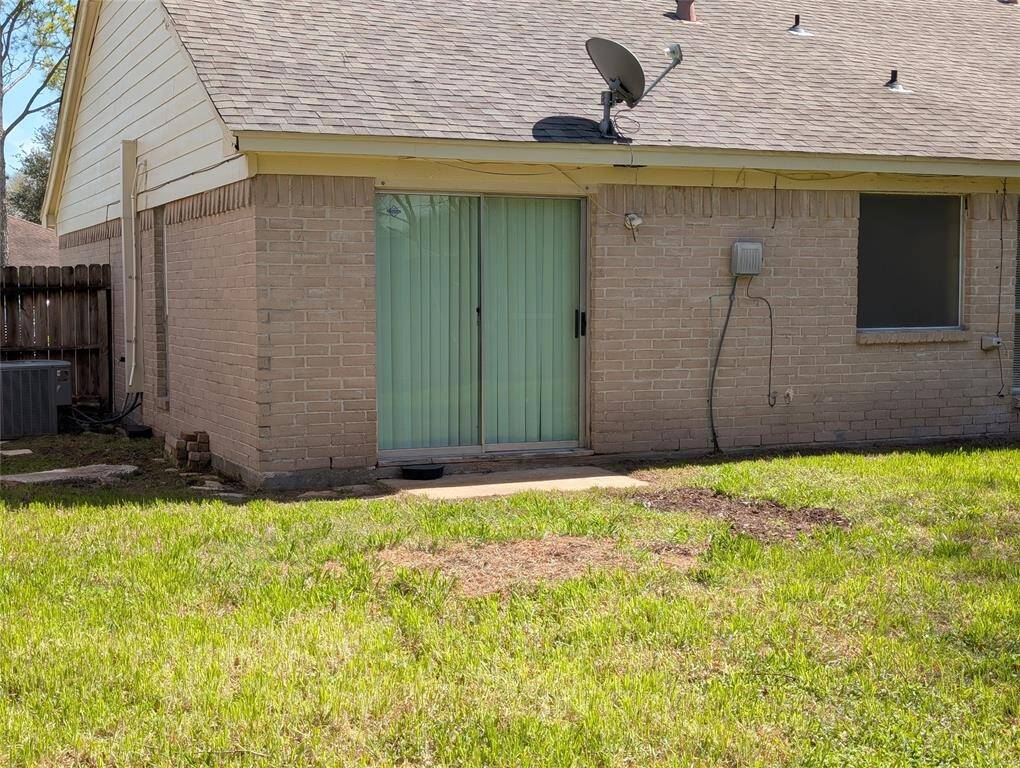 Other side of house shows the sliding glass patio door from the master bedroom.  On the right is the frosteed window over the bathtub.