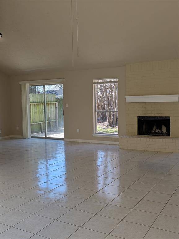 Huge living area with tile. Woodburning fireplace, lots of natural light and a sliding patio door leads out to back yard.