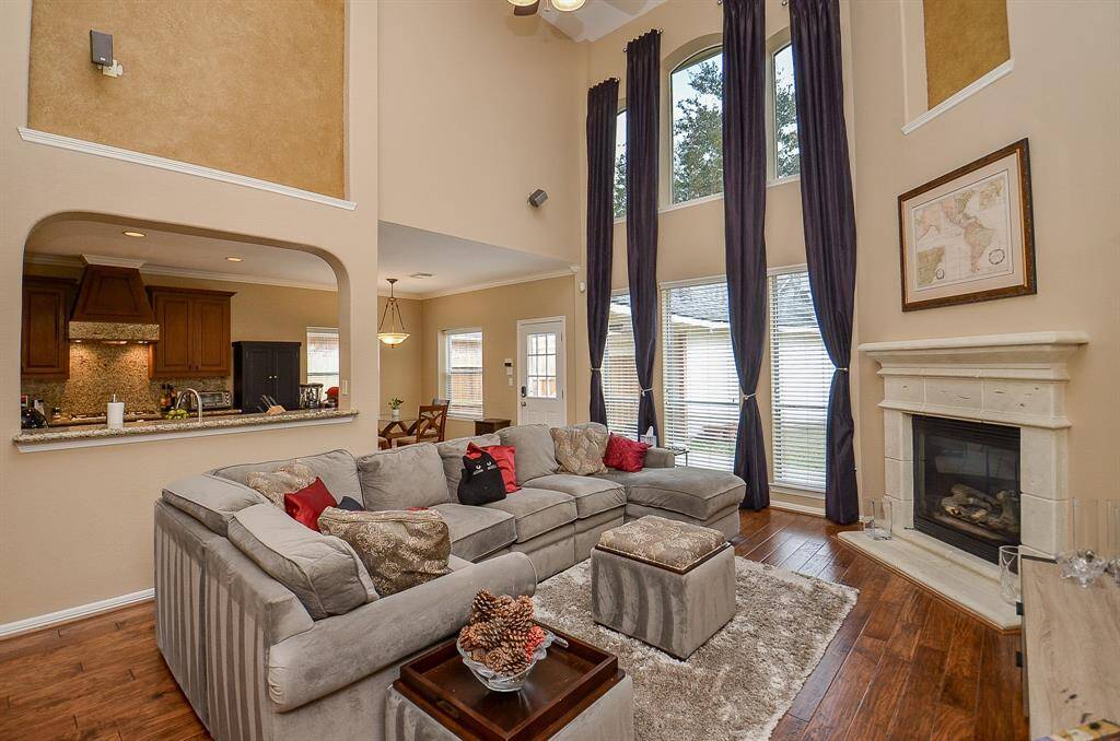 Large Family Room with hardwood floors and a soaring ceiling with a wall of windows!