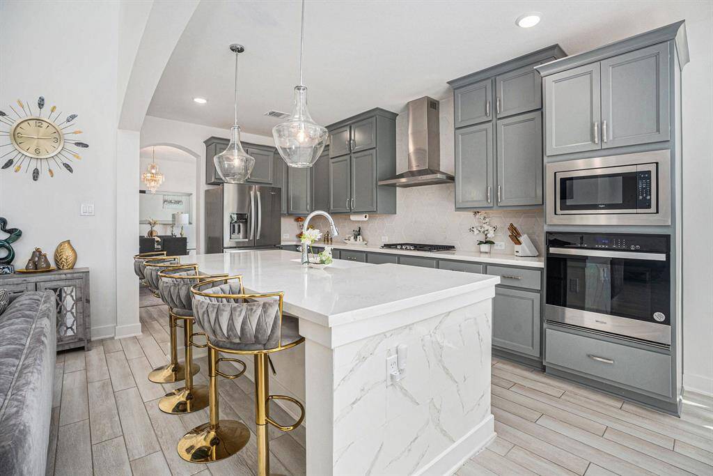 The spacious kitchen features a large center island with stunning quartz countertops. Additional seating at the island seamlessly connects the living and dining areas creating the ideal gathering spot for hosting family and friends.