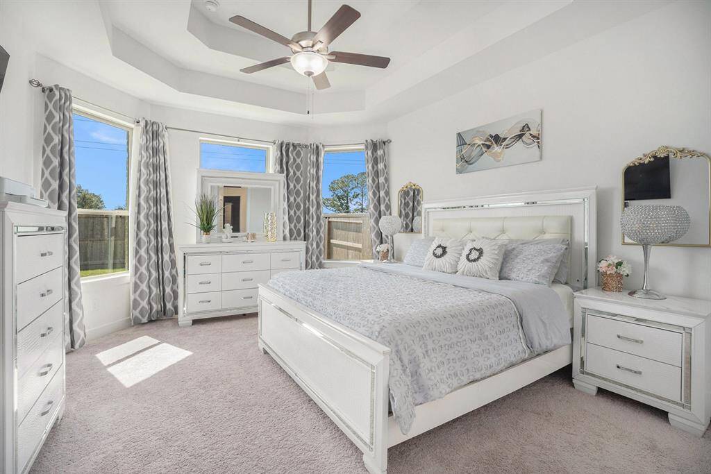 The primary bedroom offers an elegant tray ceiling and large bay window that invites gorgeous natural light.