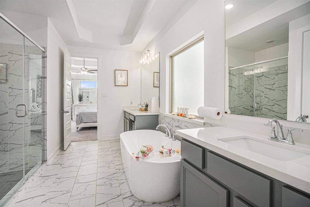 The luxurious primary en-suite bathroom features double vanities, large walk-in shower, and a spa-like soaking tub.