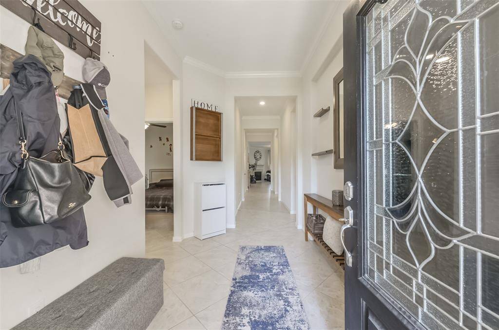 Tile floors in all main living areas. Neutral paint, crown molding. Primary bedroom is towards the back of the home and secondary bedrooms split up front.