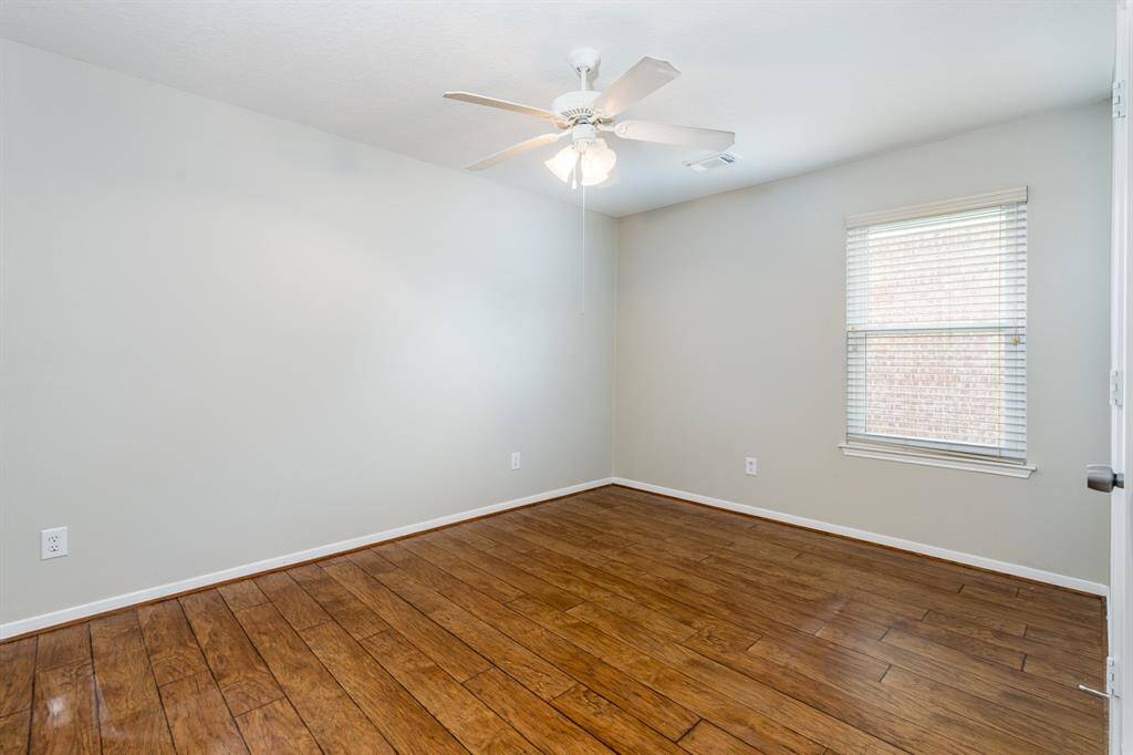 One of three secondary bedrooms all with wood flooring.