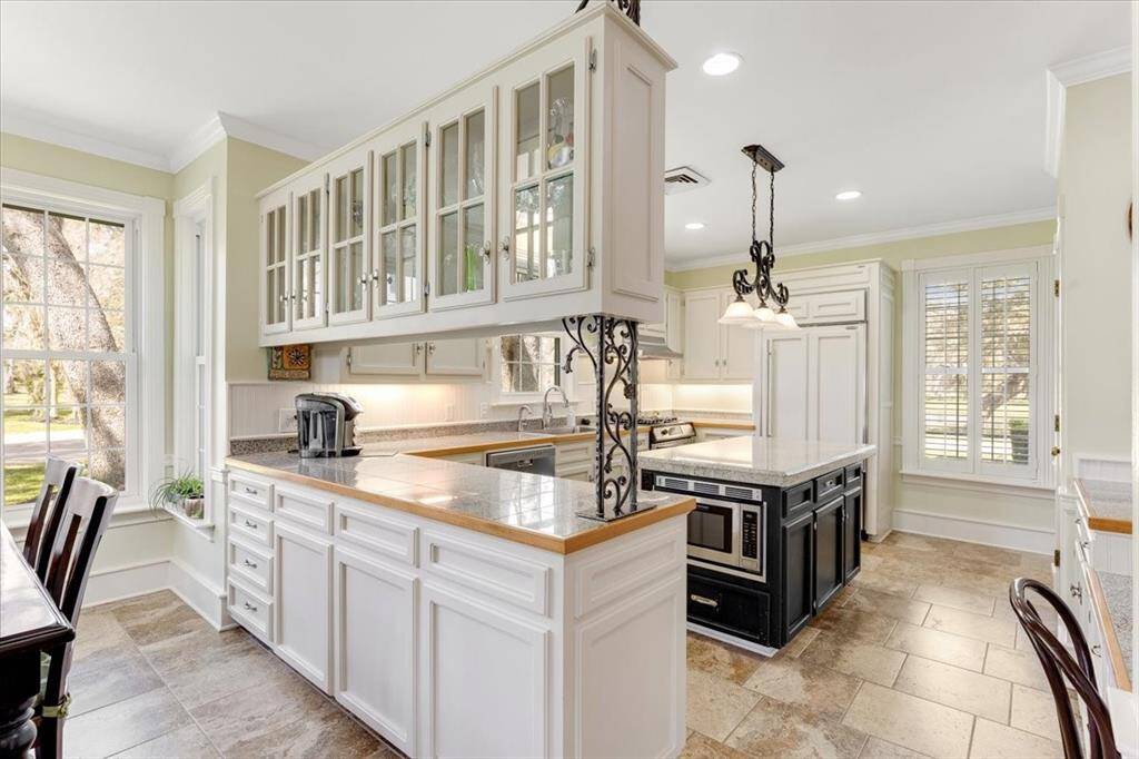Glass front cabinetry separating the breakfast area and the kitchen