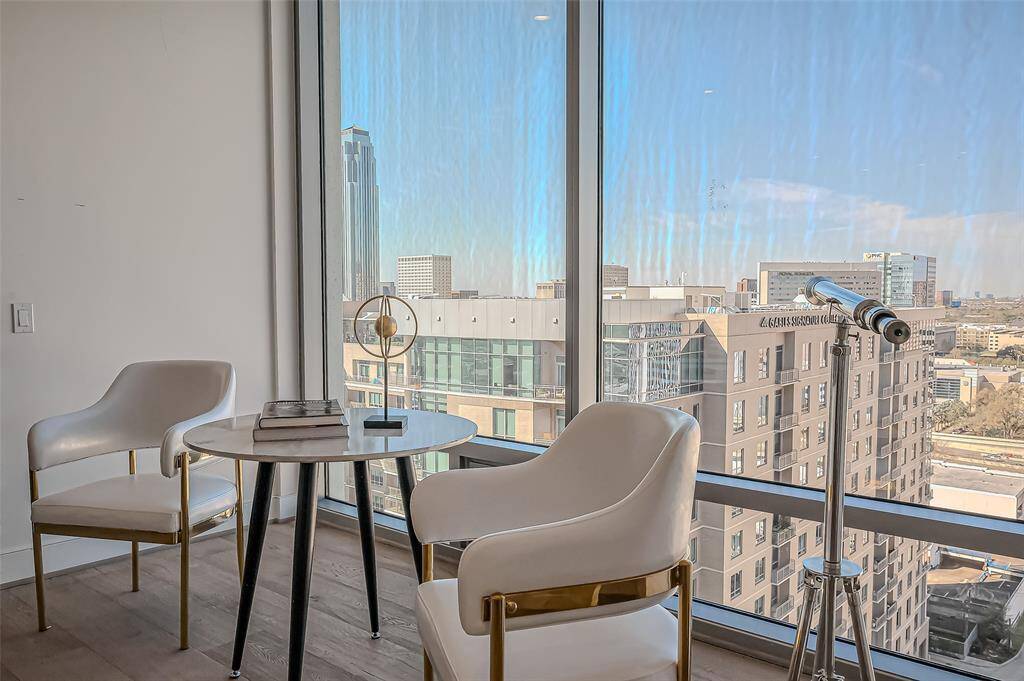 Stylish home office  Light wood flooring and neutral walls create a bright, inviting atmosphere, complemented by natural light streaming from an adjacent room.
