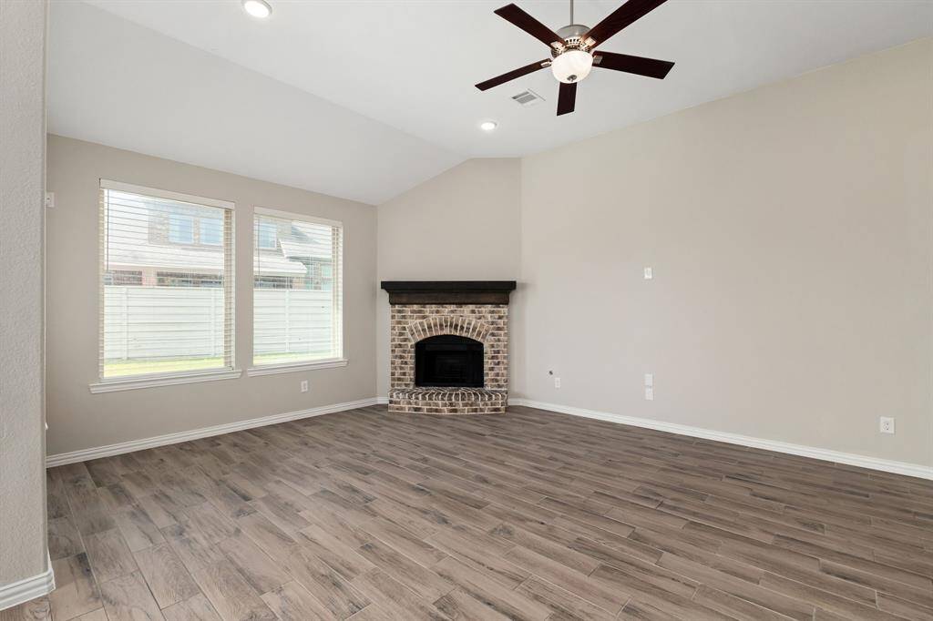 The den features high ceilings and a corner fireplace!