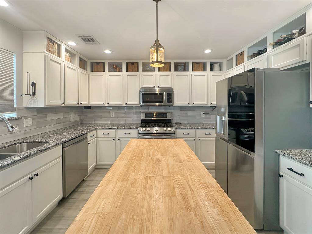 Modern kitchen featuring sleek countertops and stainless steel appliances.