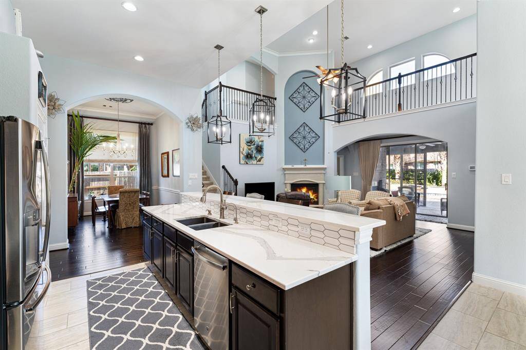 Seamless flow from kitchen to living! Enjoy soaring ceilings, elegant lighting & a cozy gas-log fireplace, all overlooking the backyard oasis.