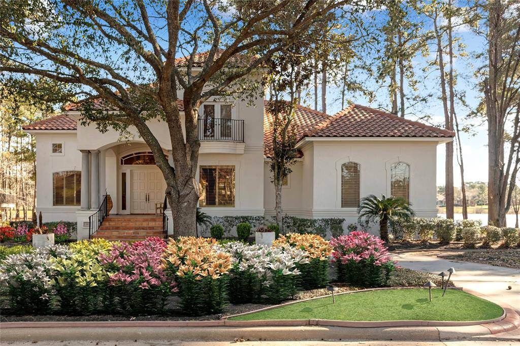 Welcome to 26 W Shore Dr. this home sits on a spectacular lot with golf and views of Lake Conroe. The flowers in this picture are virtually staged.