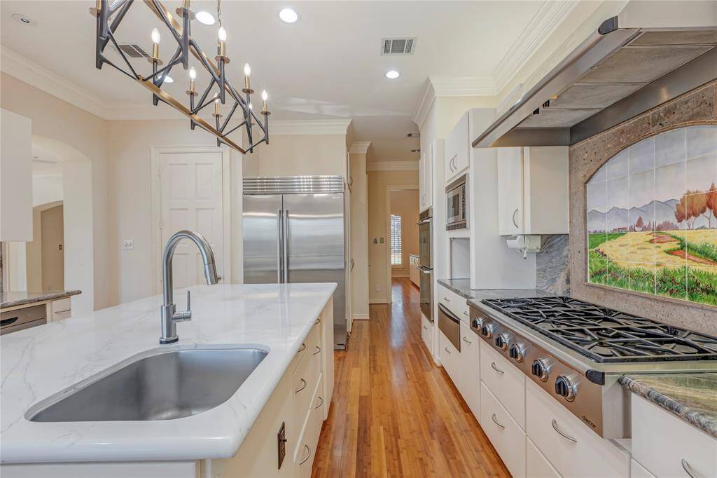 View into butlers pantry, dining area, and 2023 Subzero refrigerator.