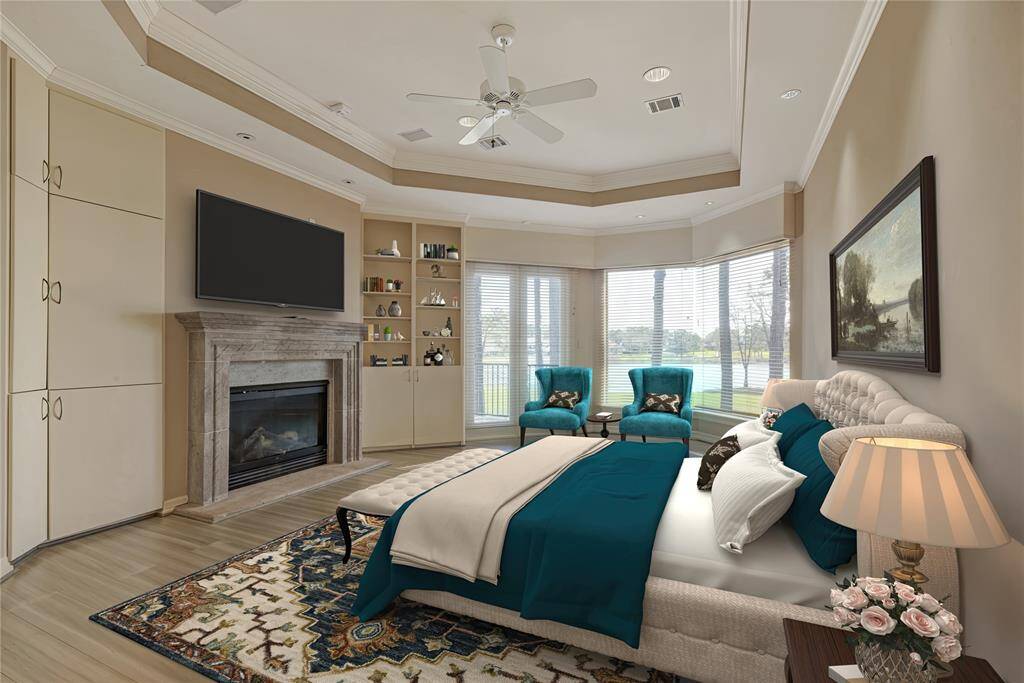The primary suite with gas fireplace, views of the golf course and Lake Conroe.  Sitting area and built-ins.