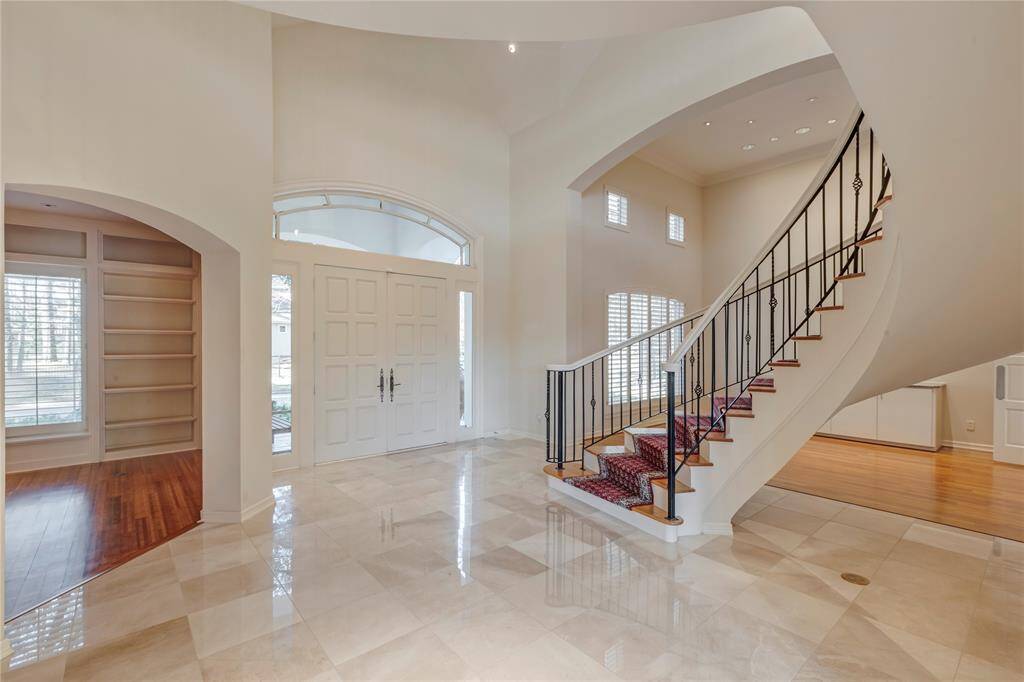 View of entryway, grand stairway, office to left and dining room to right.