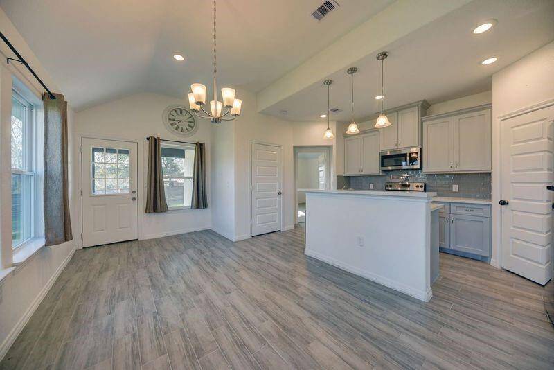 Standing between the living and dining room, looking towards the kitchen