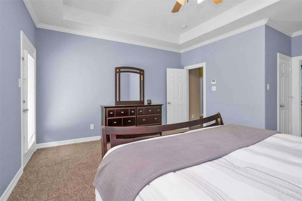 Primary bedroom has access to the covered back porch. There's room for king size bed and larger scale furniture.