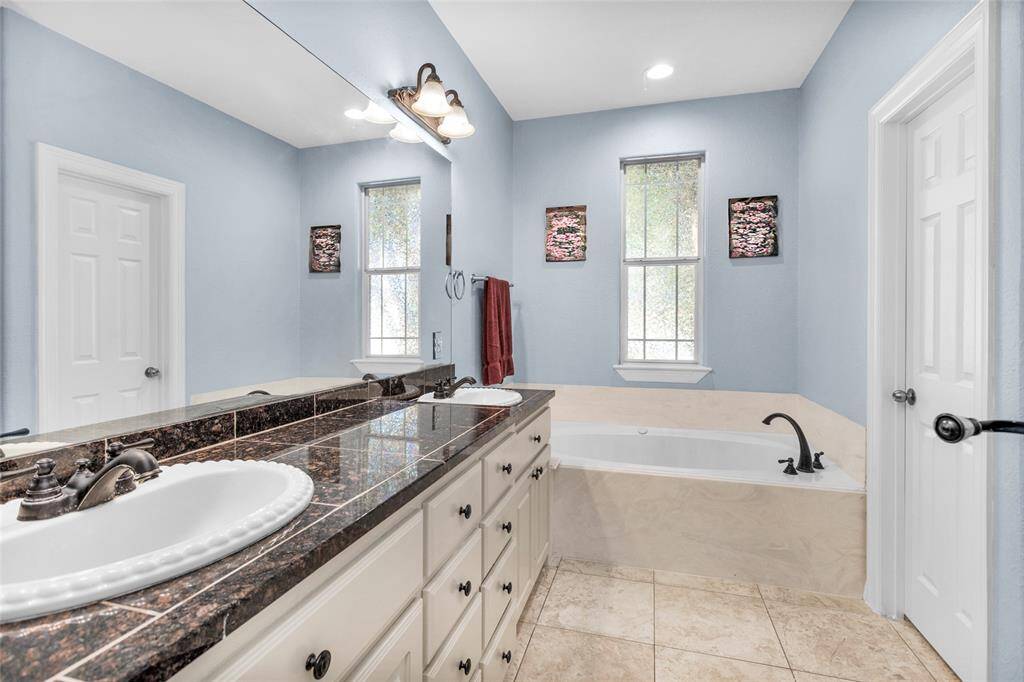 Primary bathroom ~ dual sinks, jetted sunken tub, separate shower, linen closet and lots of cabinet space!