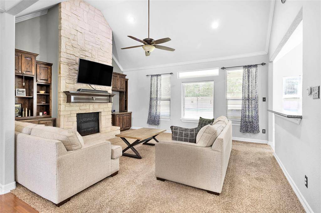 The living space focal point is the floor to ceiling stone accented wood-burning fireplace, custom cabinetry, and vaulted ceiling. Great space with a view to the backyard!