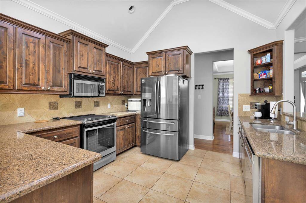 The kitchen has rich wood cabinets and granite countertops.