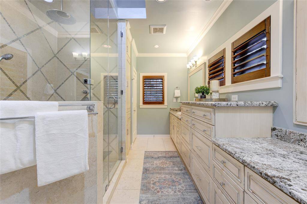 The bathroom also boasts high-end fixtures, recessed lighting, and a large, strategically placed mirror that enhances the sense of space and light.