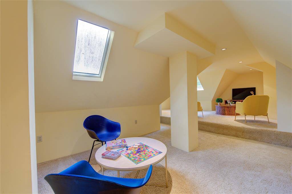 The second-floor game room offers a versatile space perfect for recreation and entertainment. Featuring plush carpeting, recessed lighting, and large windows that bring in natural light, this room is ideal for family game nights, movie marathons, or a play area for kids.