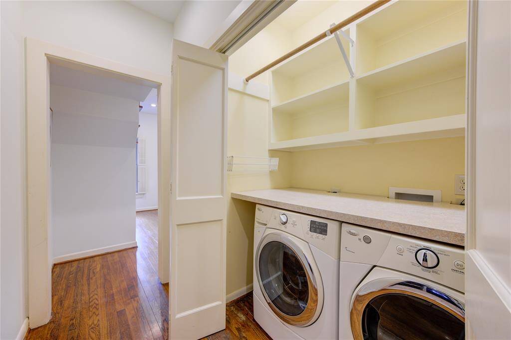 The first-floor laundry room is both functional and convenient, featuring ample storage with built-in cabinets and shelving. Equipped with a washer and dryer that stay with the home, this space is designed to make laundry tasks easier.