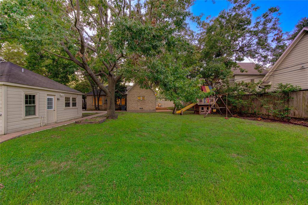Beautifully maintained garden area with a variety of flowering plants, shrubs, and trees, adding to the backyard's charm and providing a picturesque view from inside the home.