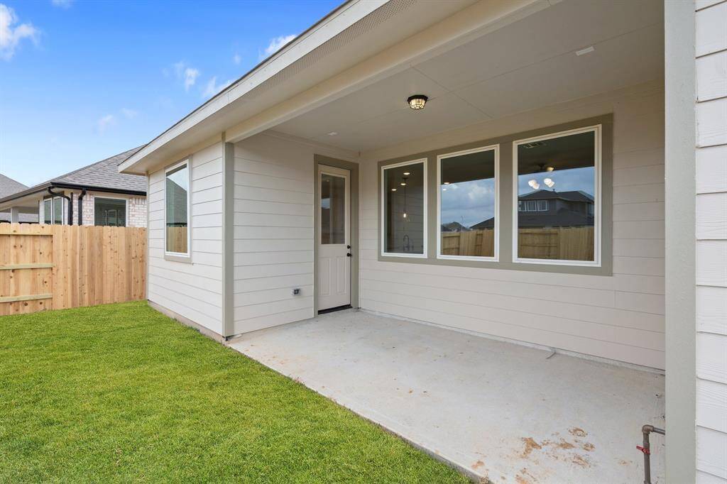 The covered patio is generously sized, providing ample space for various outdoor activities.