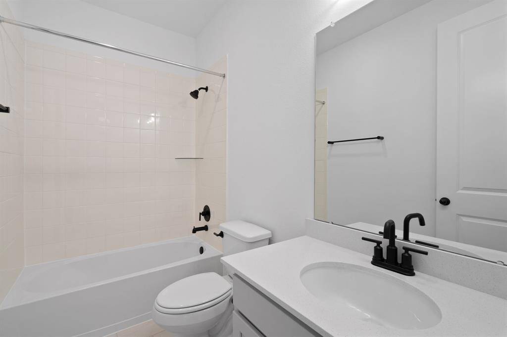 The secondary bath features tile flooring, white cabinetry and light countertops and a shower/tub combo. Perfect for accommodating any visiting family and friends.