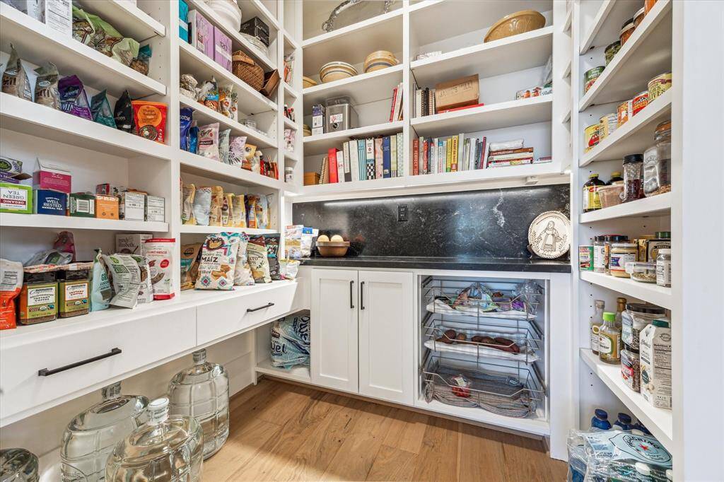 Amazing pantry with floor to ceiling adjustable shelves, 3 vegetable bins, and black mist granite countertop.