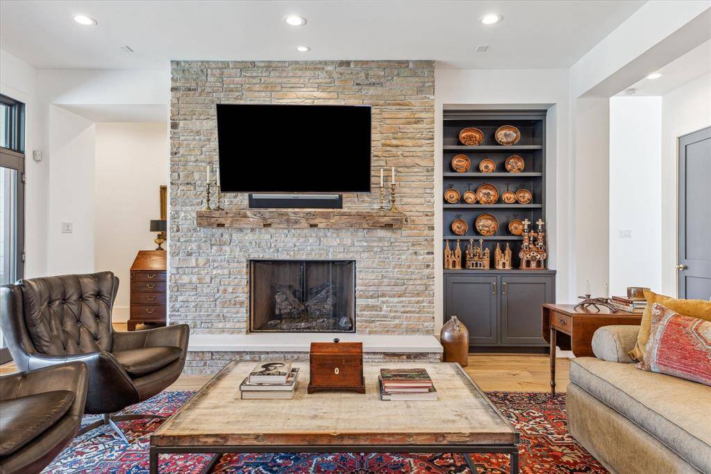 Fireplace wall of reclaimed ledgestone from an old Braes Height mid-century modern home.  Mantle was sourced from an old barn in New England.