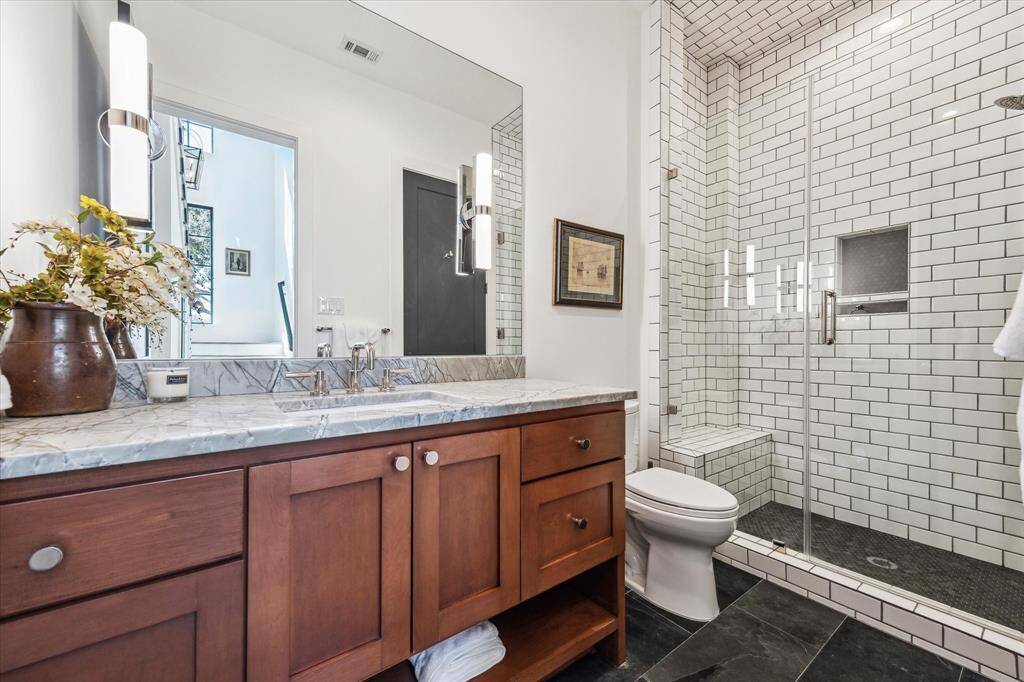 Downstairs guest bath with with quartzite counter tops glass shower doubles as a secondary powder room off the family room.