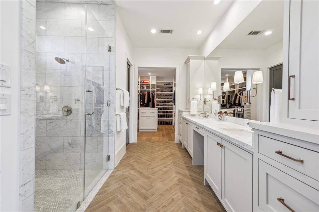 Marble shower with Rain Shower head and seamless glass door.
