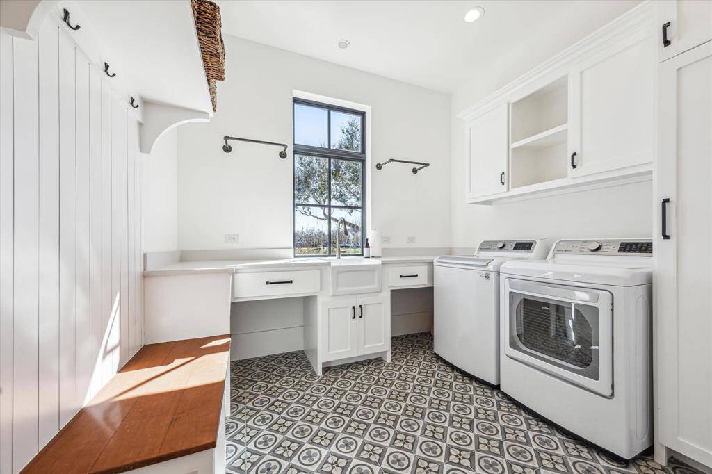 Well-appointed utility room doubles as a mudroom with stylish tile floor (Quartetto-Cool Petalo), quartz counter top and broom closet.