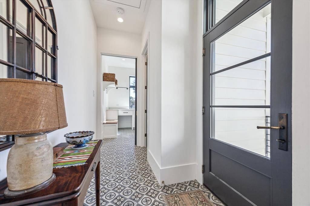 The tile floor (Quartetto-Cool Petalo) extends to the secondary powder room and side entry.